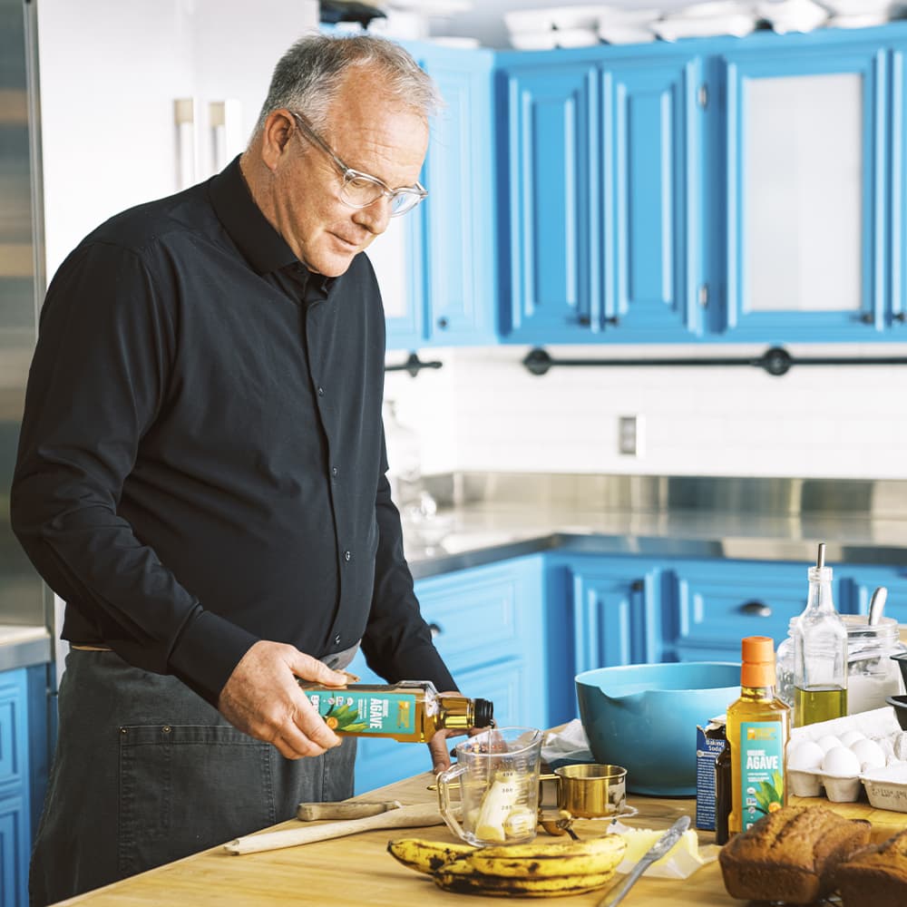 Stephen Richards using BetterBody Foods agave in a kitchen.